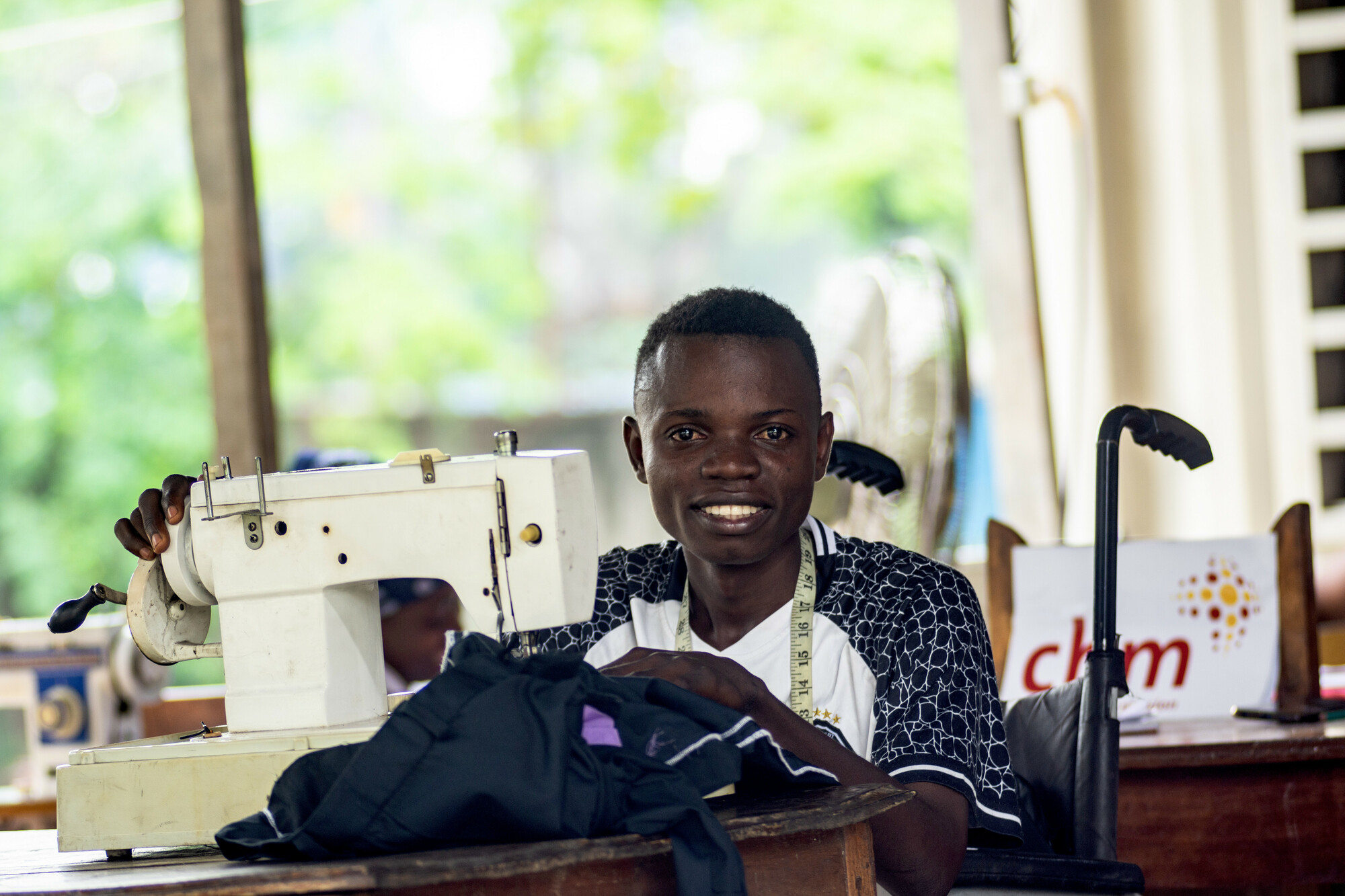 Jordan, a 25-year-old with a leg disability from wild poliomyelitis due to lacking vaccination, was identified at a Catholic parish through a CBM-funded project in Congo. He is now enrolled in a sewing training center.