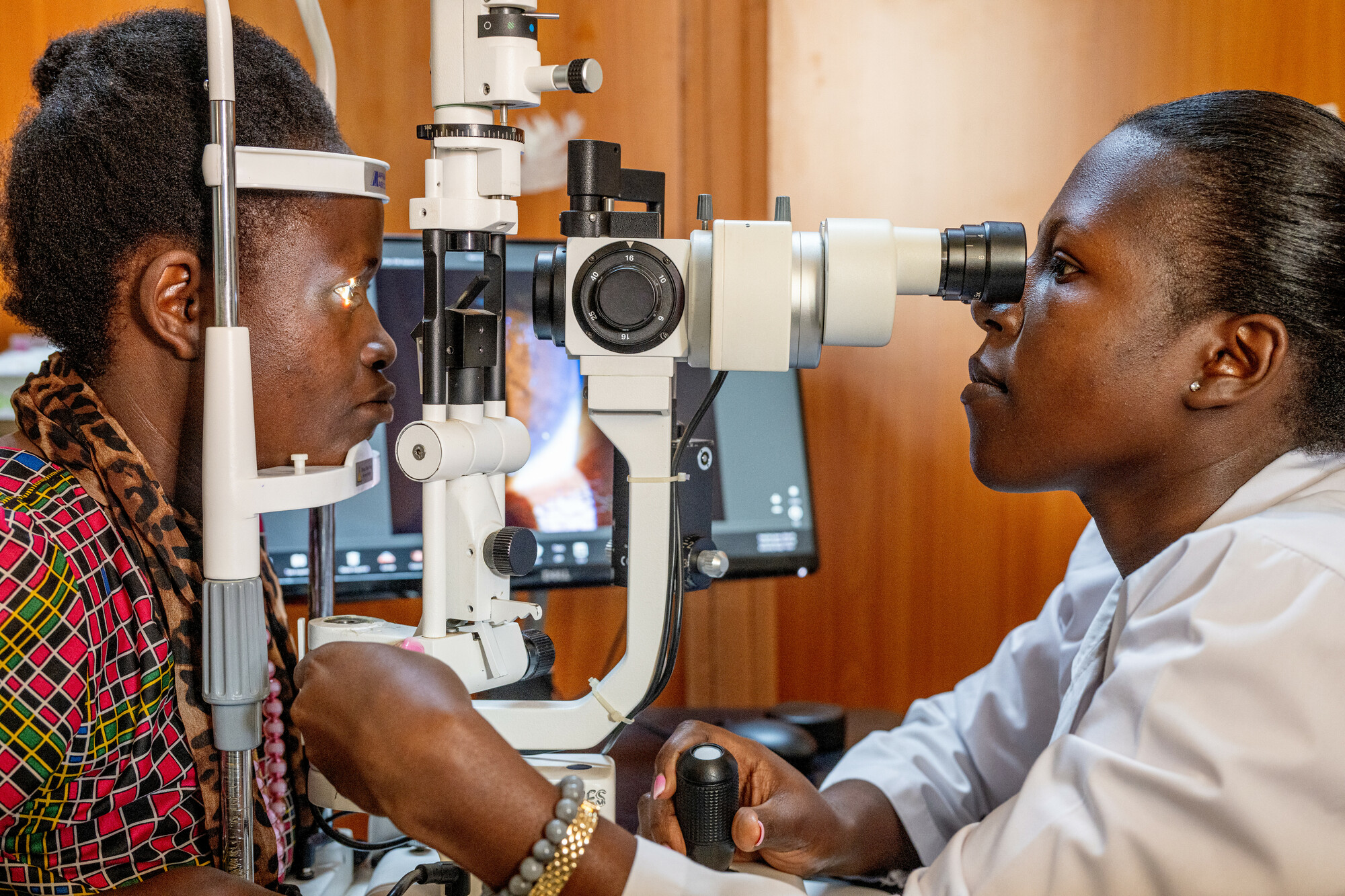 Dr. Teddy Zalwango examines a patient using a slit lamp at Mbarara University of Science and Technology (MUST). She is a beneficiary of the CBM scholarship program, which supports healthcare practitioners across Africa. The program offers twelve scholarships for doctors seeking postgraduate studies in ophthalmology.<br/><br/>